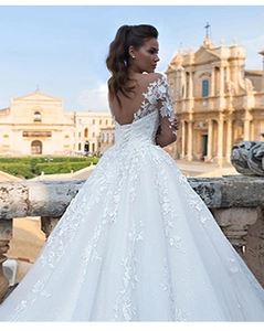 Exquisite back detail of a long-sleeved lace wedding dress with V-neck and open-back design