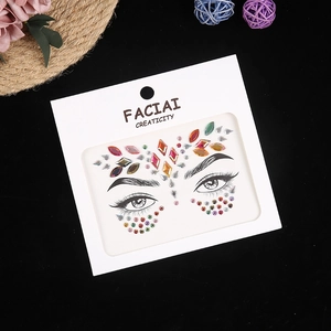 Detailed view of colorful face jewels stickers on white card for music festival makeup