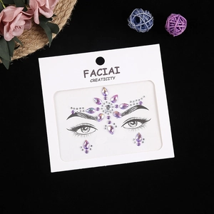 Detail shot of purple acrylic face jewels set on card with decorative dried flowers