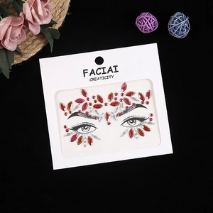 Macro shot of red and clear crystal face jewels on cardstock for festival party makeup decor