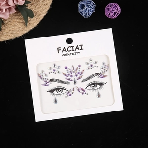 Detailed view of purple and white crystal face jewels for eye makeup on black background