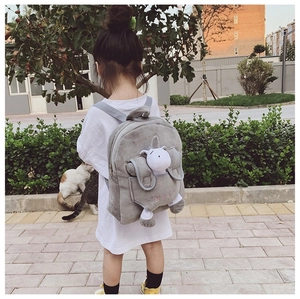 Close-up of a grey plush children's backpack featuring a cute white unicorn doll