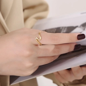 Polished gold wave ring for women showing a minimalist geometric curved design