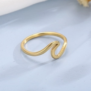 Macro detail of wave-shaped golden titanium steel ring with high polished finish
