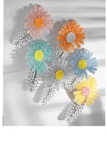 Close-up of five colorful daisy hair clips with textured petals and silver metal base
