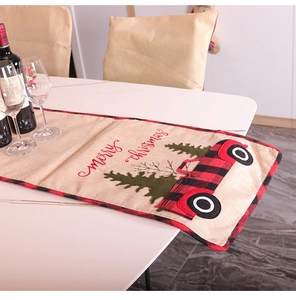Detail of linen Christmas table runner with red truck and Merry Christmas embroidery