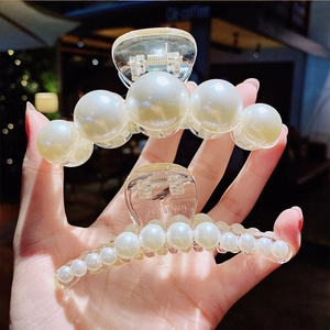 Elegant pearl hair claw clip with large white faux pearls on a clear acrylic base for women