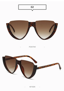Detail view of leopard print cat eye sunglasses with brown gradient lenses at a 45-degree angle