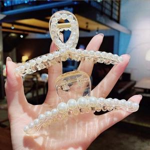 Elegant set of two pearl hair claws featuring transparent resin and gold-tone springs