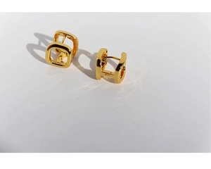 Macro detail of gold plated hollow square hoop earrings with a high polish finish