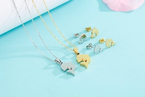Detail of dolphin jewelry set featuring gold and silver necklaces and stud earrings