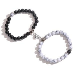 Detail of magnetic heart clasp connecting black and marble bead bracelets for couples