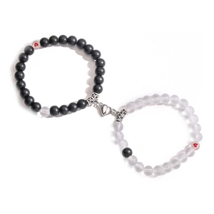 Detail of magnetic heart clasp connecting black and frosted white couple bracelets