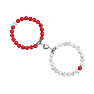 Macro detail of red and white beaded bracelets with heart-shaped magnetic clasp