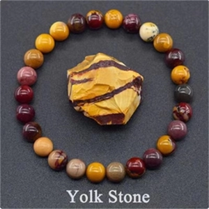 Detailed view of elastic yolk stone bead bracelet with a central yellow striped gemstone