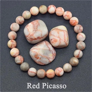 Detail of Red Picasso Jasper beaded bracelet with matching tumbled stones on grey background