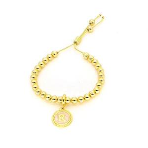 Détail du bracelet à perles dorées 18 carats avec fermoir réglable et breloque lettre R