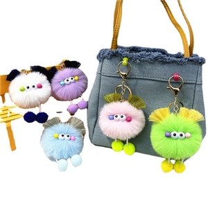 Colorful plush doll keychains in five bright colors hanging on a blue denim bag