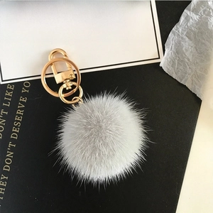 Detailed view of soft gray fur ball keychain with high-quality gold metal hardware hooks