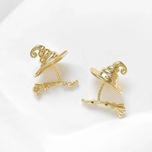 Detailed close-up of gold-plated witch hat and broom earrings with micro-inlaid stones
