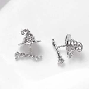 Detailed macro shot of silver witch hat and broomstick metal jewelry charms