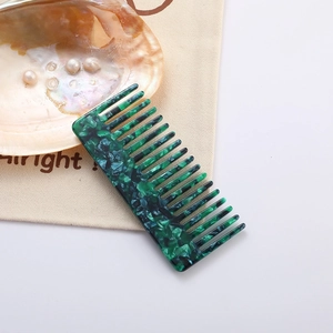 Green marble acetate wide tooth comb on canvas with shell and pearl decor