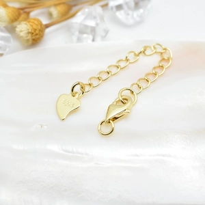 Macro shot of S925 sterling silver golden extension chain with heart tag and lobster clasp