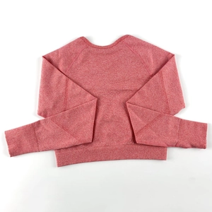 Dettaglio del top da yoga in maglia rosa mélange con polsini a coste e maniche raglan