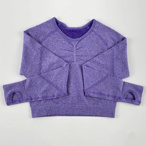 Dettaglio del crop top viola senza cuciture con fori per i pollici e design arricciato