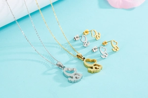 Vue à plat des colliers et boucles d'oreilles cœur évidé en or et argent sur bleu