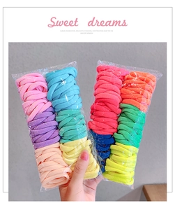 Close-up of vibrant candy-colored elastic hair ties in bulk transparent packaging