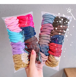 Close-up of assorted candy-colored elastic hair ties in a bulk transparent packaging