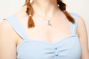 Detail view of a silver stainless steel snake chain necklace worn by a fashion model