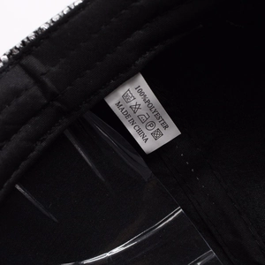 Detailed care label showing 100% polyester fabric and washing instructions for baseball cap