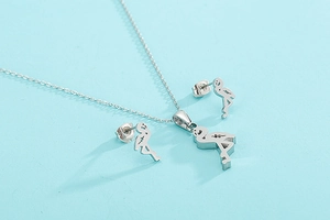 Polished silver flamingo pendant necklace and stud earrings set on light blue background