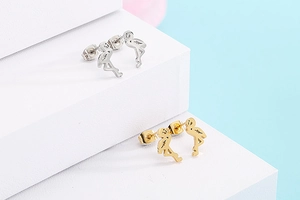 Detail of flamingo stud earrings in gold and silver finish on a decorative platform