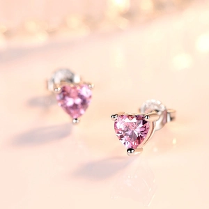 Close-up of pink heart-shaped crystal stud earrings in a rose gold-plated three-prong setting