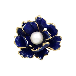 Close-up of deep blue enamel flower brooch with gold edges and center pearl accent