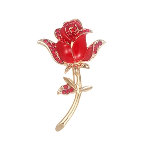 Detailed close-up of red enamel rose brooch with sparkling zircons and gold-plated stem