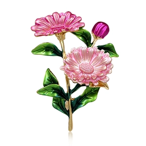 Detail of pink and green daisy flower brooch with golden alloy base and enamel petals
