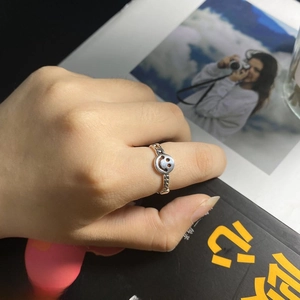 Detail of adjustable silver smiley face ring made of alloy shown on a magazine background