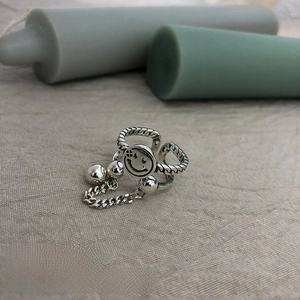 Detail of adjustable vintage silver alloy ring with smiley charm and chain elements