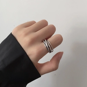 Close-up of adjustable silver multi-layer wrap ring in minimalist industrial style