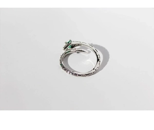 Detailed view of silver snake open ring with green zircon stones and scale texture