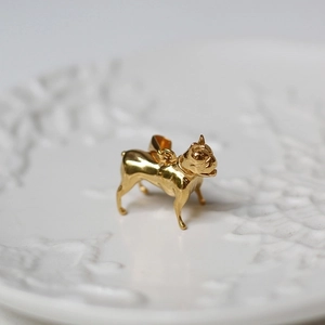 Detailed close-up of a golden French Bulldog pendant with polished metal finish