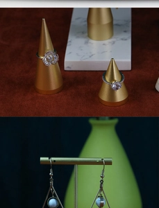 Macro shot of geometric earrings with blue beads and diamond rings on golden stands