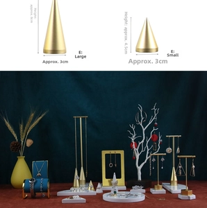 Macro detail of golden metal jewelry stands with marble tray and sizing dimensions