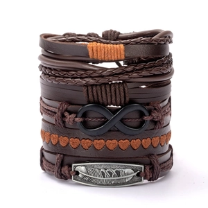 Detailed macro shot of multilayer leather bracelet with silver feather and infinity charm