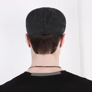 Men's herringbone flat cap in dark grey tweed shown from a stylish back view angle
