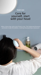 Detail showing an ergonomic light blue silicone scalp massage brush for head care during shower